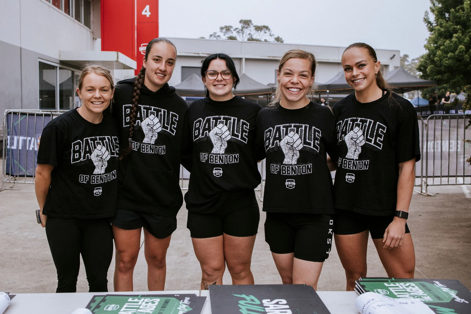 Five smiling members of the event crew in Battle of the Ages shirts