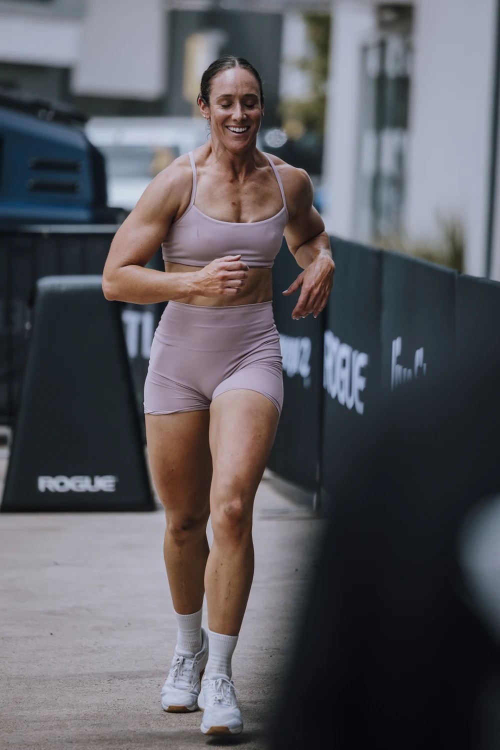 A smiling athlete running outdoors at a Benton competition